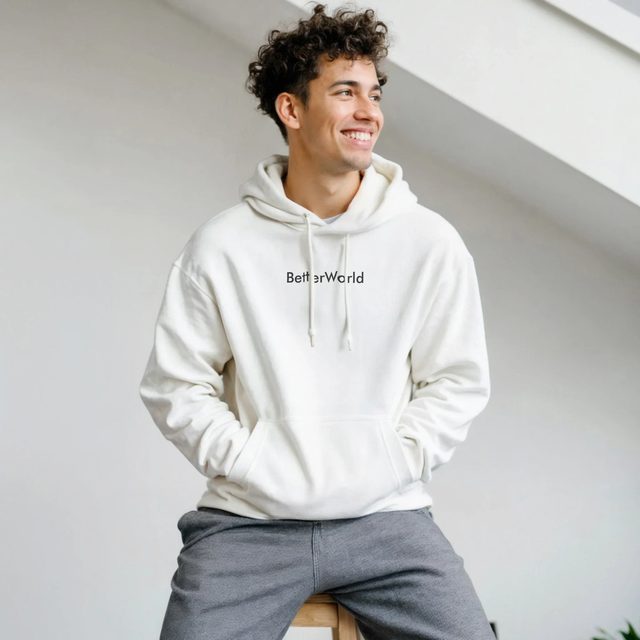 Hoodie BetterWorld unisexe crème porté par un homme souriant